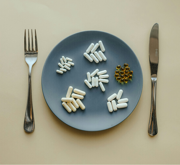 Supplements next to fresh whole food, contrasting the two approaches to nutrition